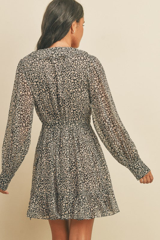 Black and beige dot pattern wrap dress with metallic gold dots, ruffle hem and balloon sleeves.