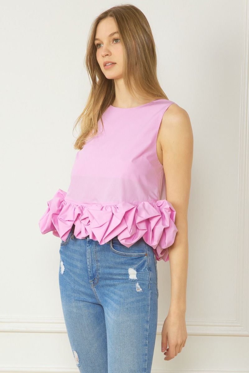 Sleeveless crop top featuring ruffle detail at hem. Button closure at back neck. Lined. Woven. Non-sheer. Lightweight.